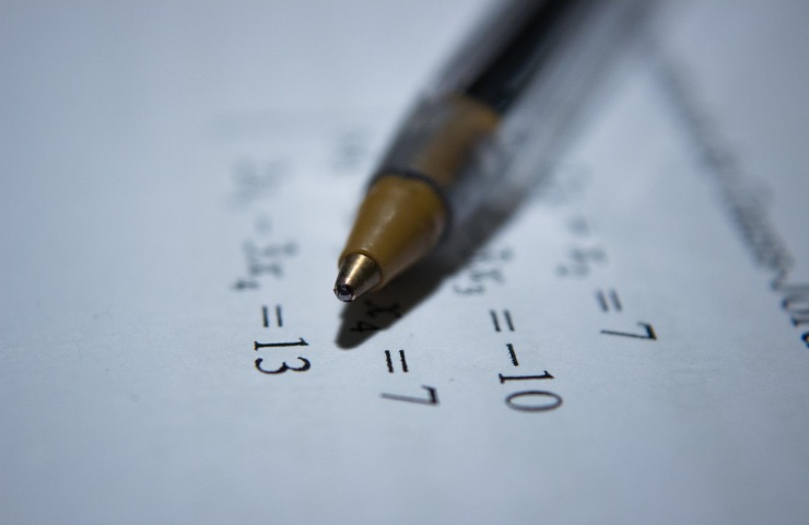 Penna appoggiata su un foglio riportante un esercizio di matematica