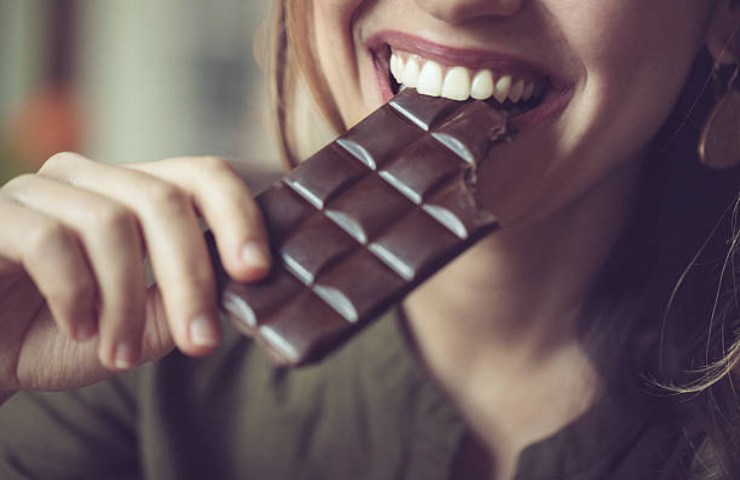 Ragazza mangia una stecca di cioccolato