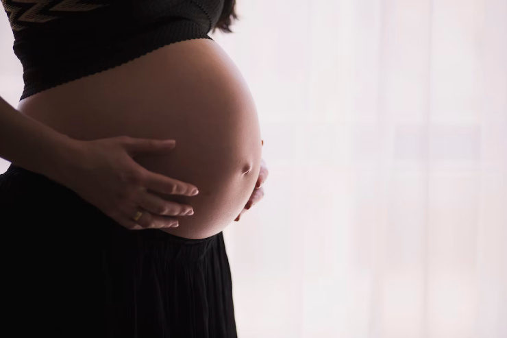 Donna in gravidanza con le mani poggiate sulla pancia